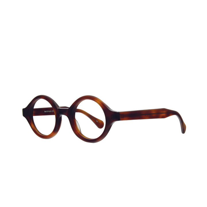Angled view of a pair of tortoise, perfectly round eyeglasses with a saddle bridge, tapered temples, and clear lenses.