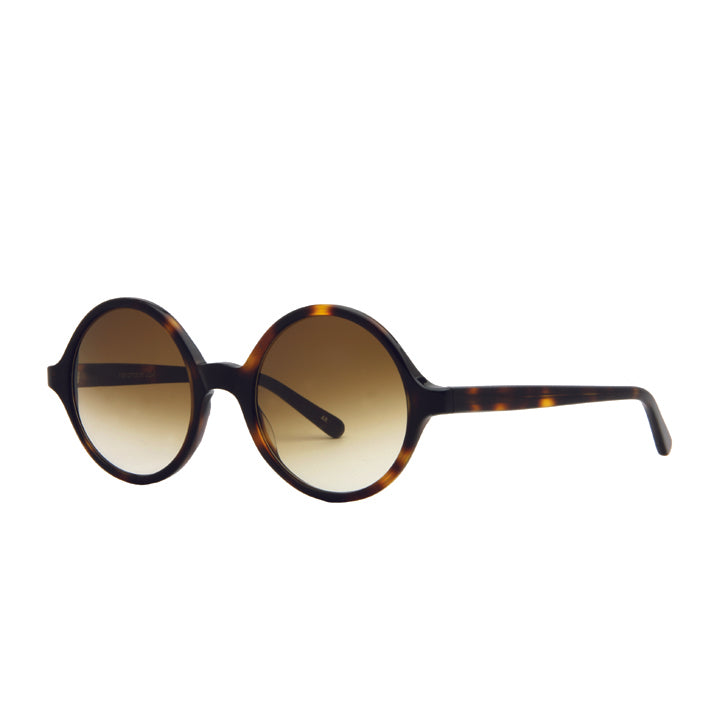 Angled view of a pair of round full frame sunglasses made of acetate, in a tortoise color pattern, with brown lenses.